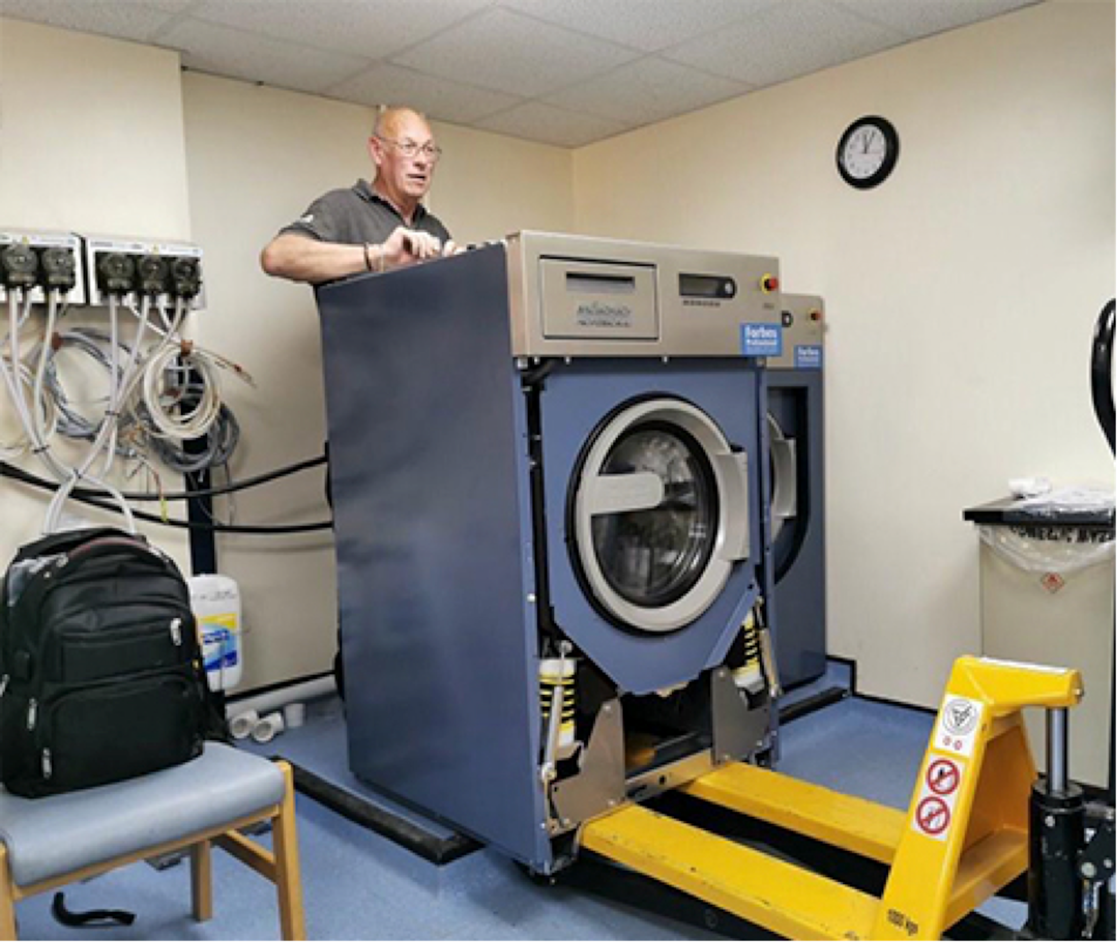 Engineer installing Miele commercial machine off loading trolly